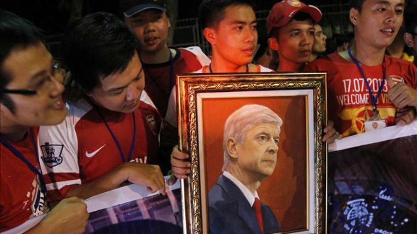 "Vijetnamski navijač drži sliku Arsena Vengera tokom iščekivanja igrača na aerodromu"