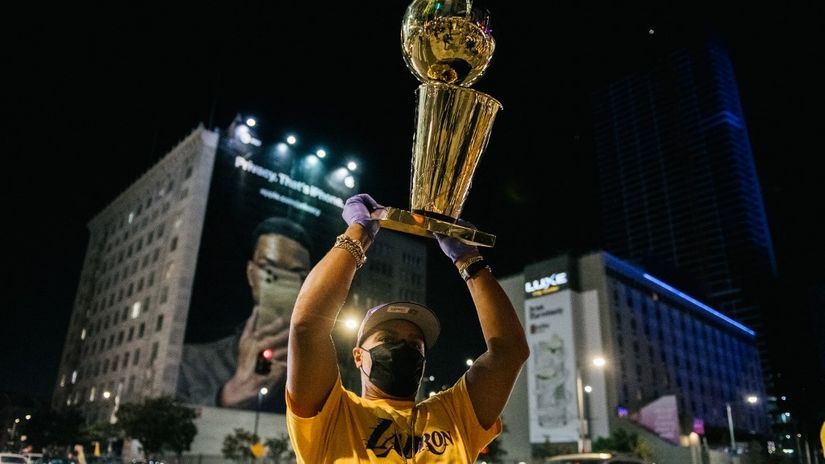 Navijač Lejkersa podiže repliku trofeja (©AFP)